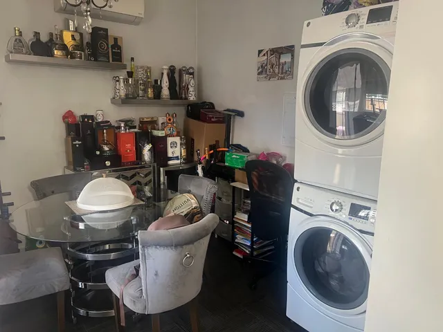 a utility room with dryer washer and a view of chair