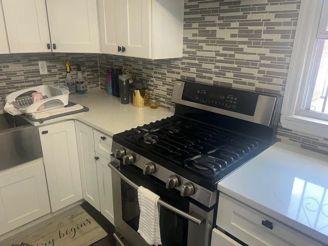 a stove top oven sitting inside of a kitchen