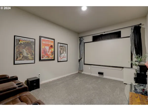 a living room with wall paintings and a flat screen tv