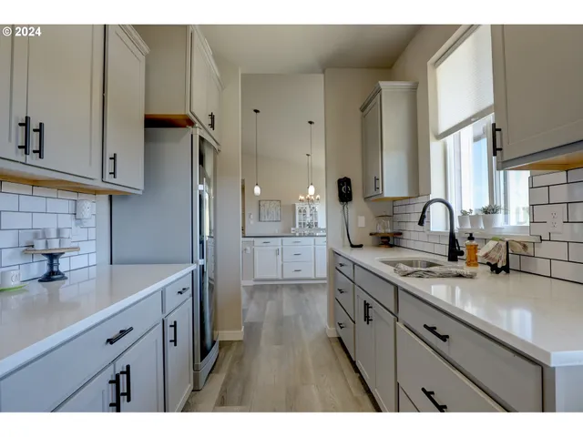 a spacious bathroom with a granite countertop double vanity sink a mirror and a