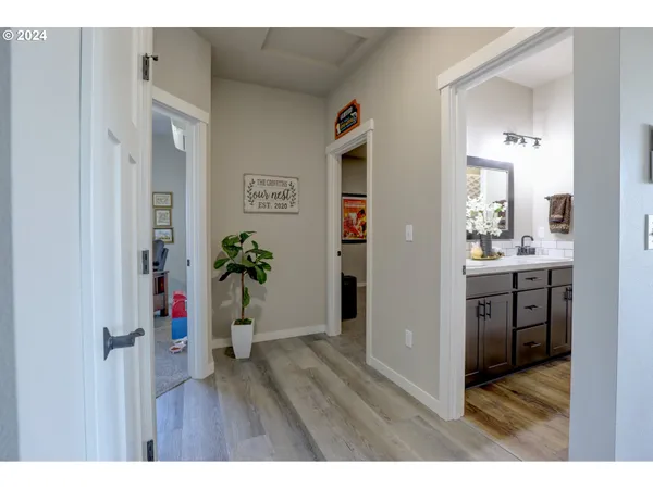 a hallway with a dining table wooden floor and a large window
