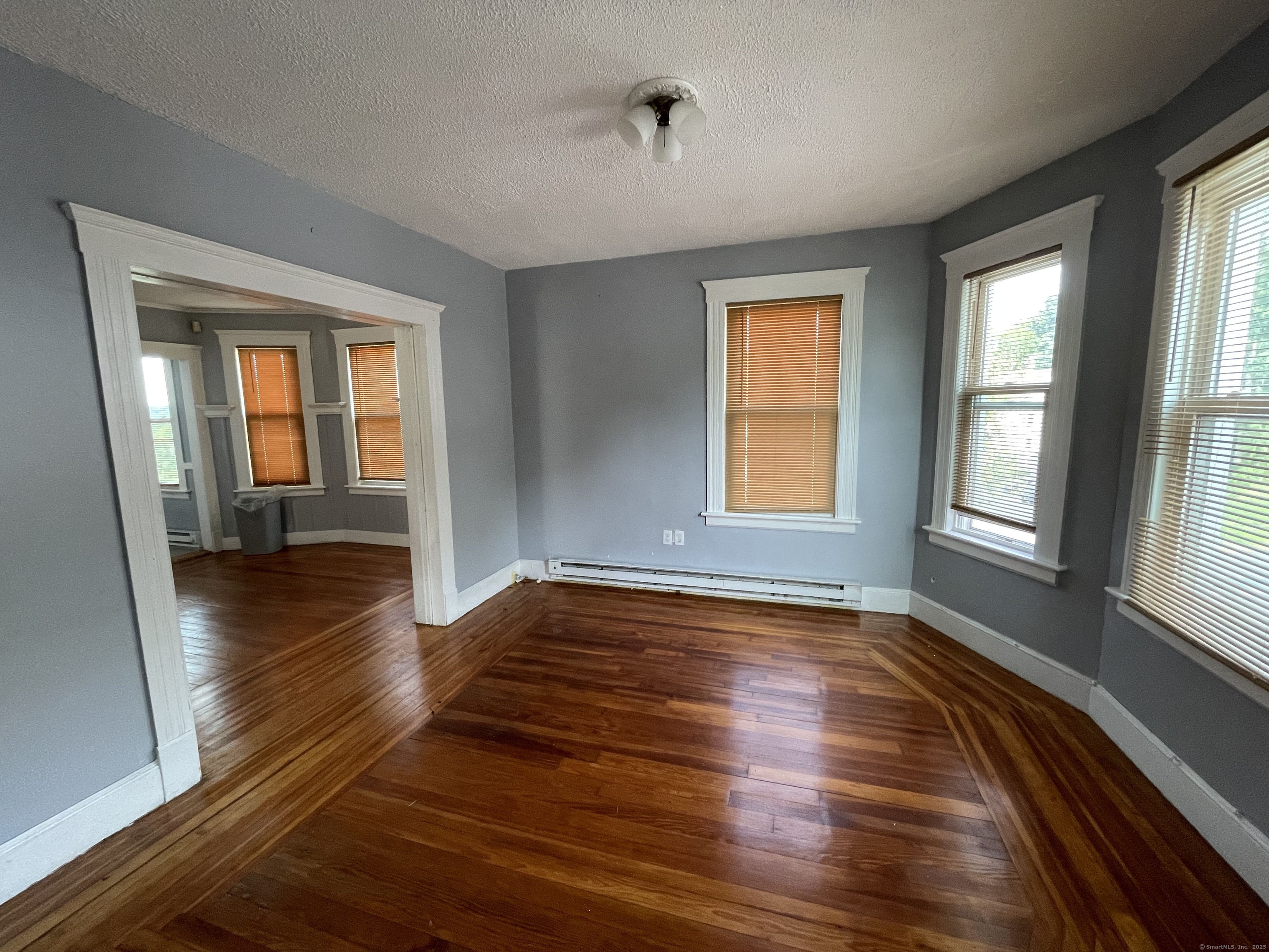 152 Wolcott Street, Unit 2 Waterbury, CT 06705 - Photo 2 of 12 a view of an empty room with window and wooden floor
