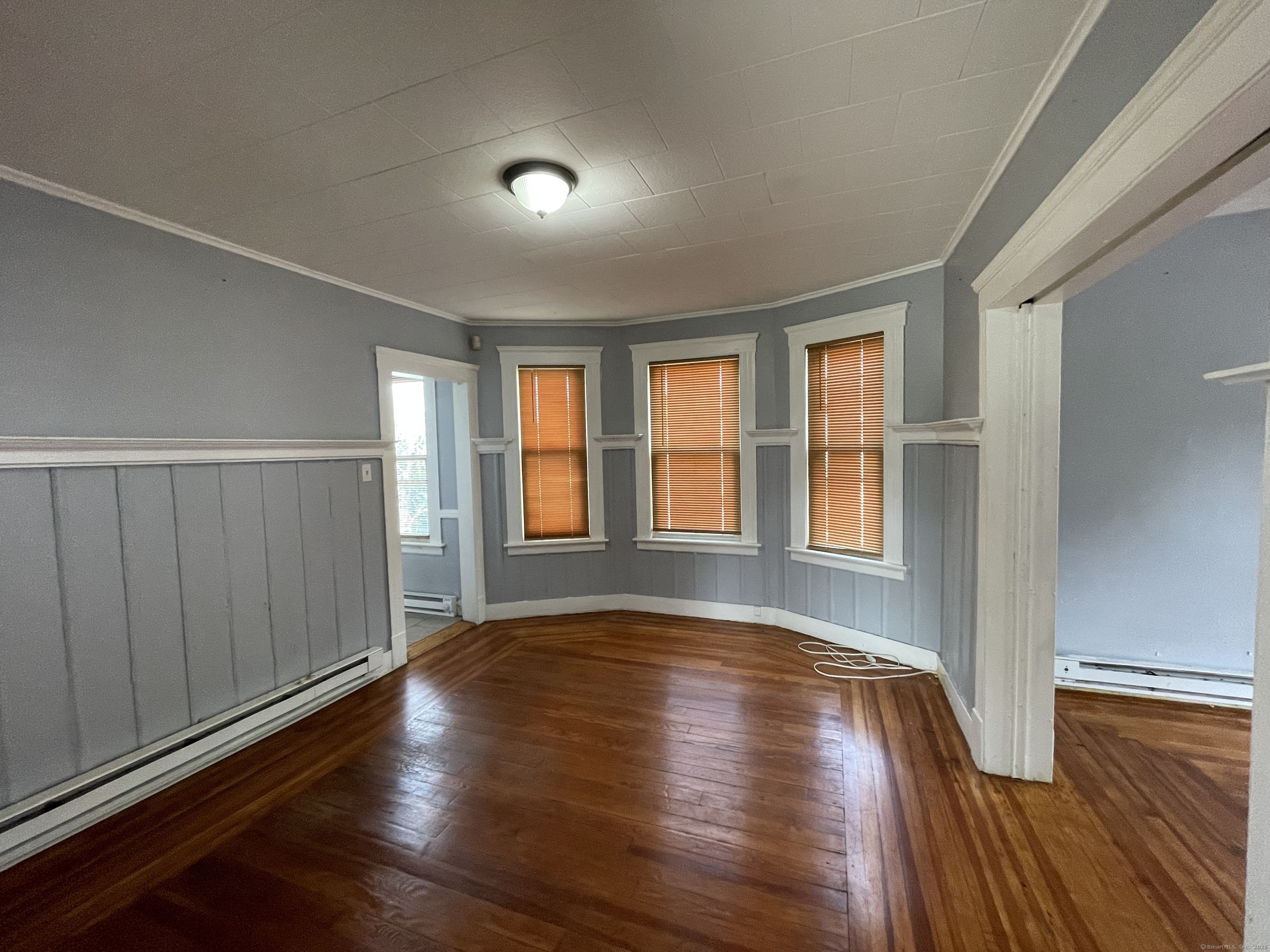 152 Wolcott Street, Unit 2 Waterbury, CT 06705 - Photo 5 of 12 a view of an empty room with wooden floor and a window