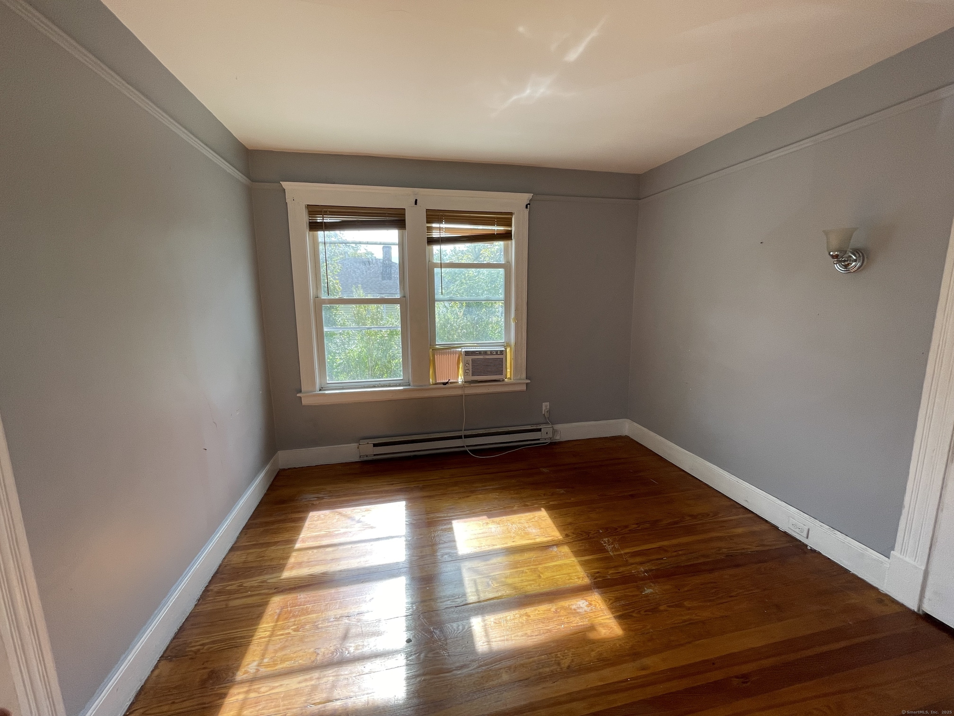 152 Wolcott Street, Unit 2 Waterbury, CT 06705 - Photo 9 of 12 a view of an empty room with wooden floor and a window
