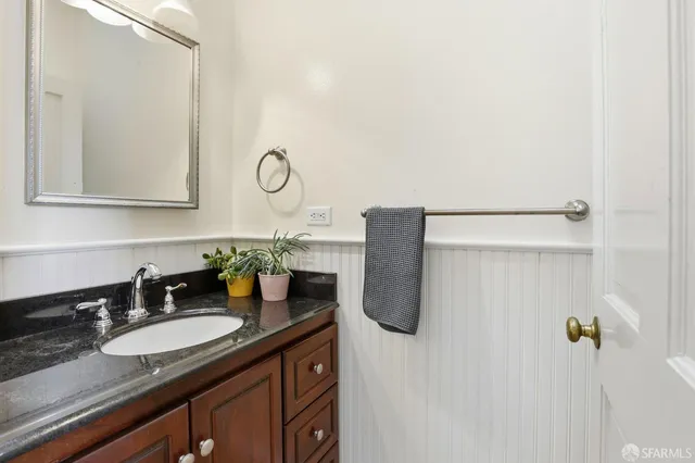 a bathroom with a granite countertop sink and a mirror
