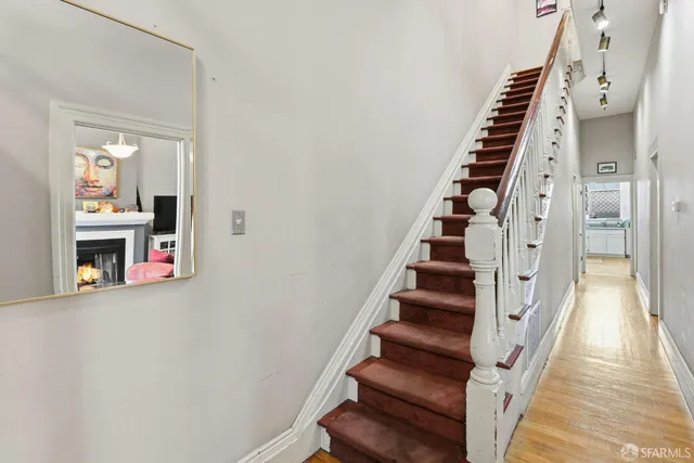 a view of staircase with wooden floor and white walls