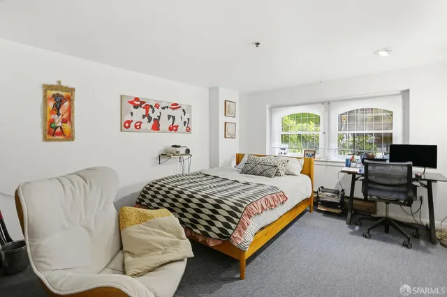 a bedroom with a bed and a large window