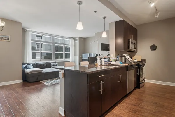 a kitchen with stainless steel appliances granite countertop a sink stove and wooden floor