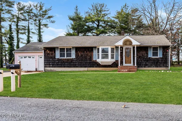 a front view of a house with a garden and yard