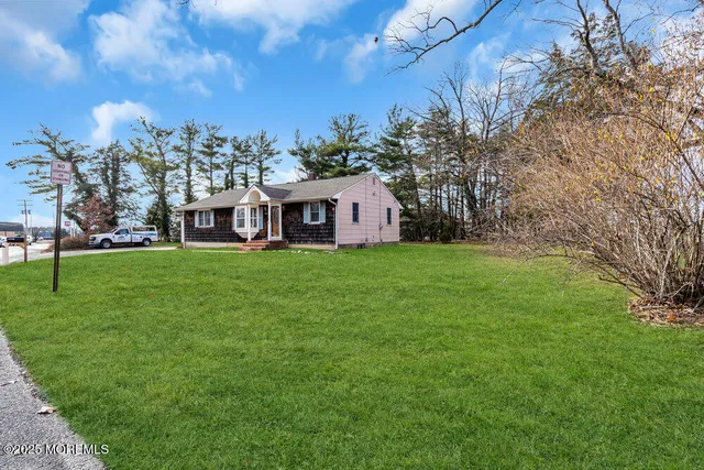 a view of a house with a big yard and large trees