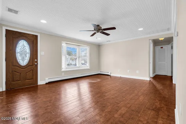 a view of an empty room with a window and a ceiling fan