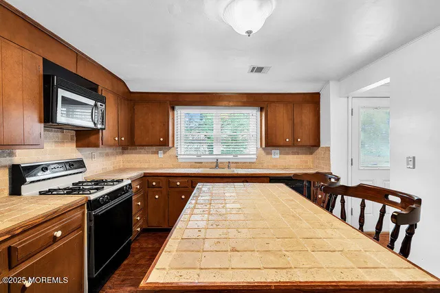 a kitchen with a stove a sink and a microwave
