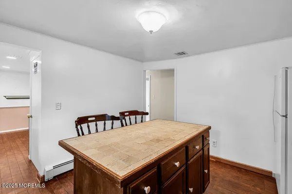 a room with a table chairs and wooden floor