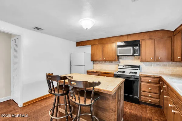 a kitchen with a stove a table and chairs in it