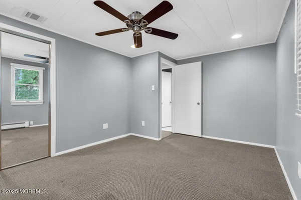 an empty room with fan and windows