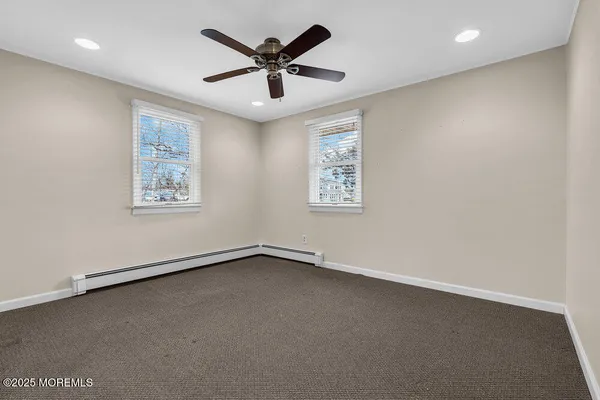 an empty room with a window and a ceiling fan
