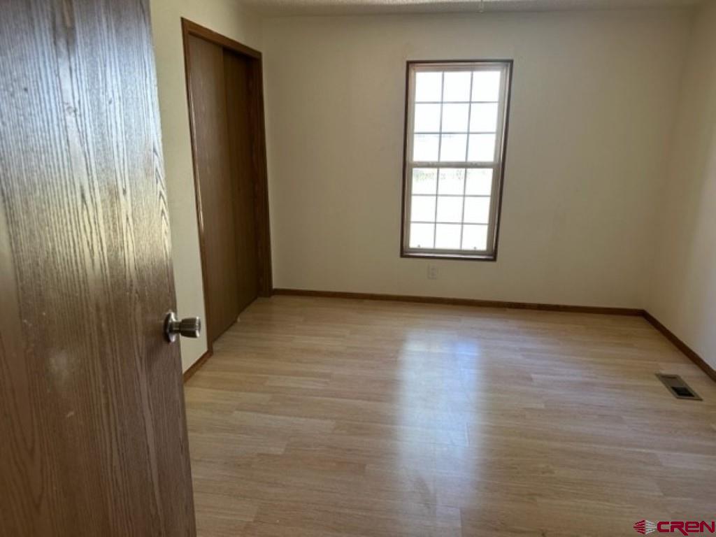 32 Hidden Lane Durango, CO 81303 - Photo 20 of 26 an empty room with wooden floor and windows