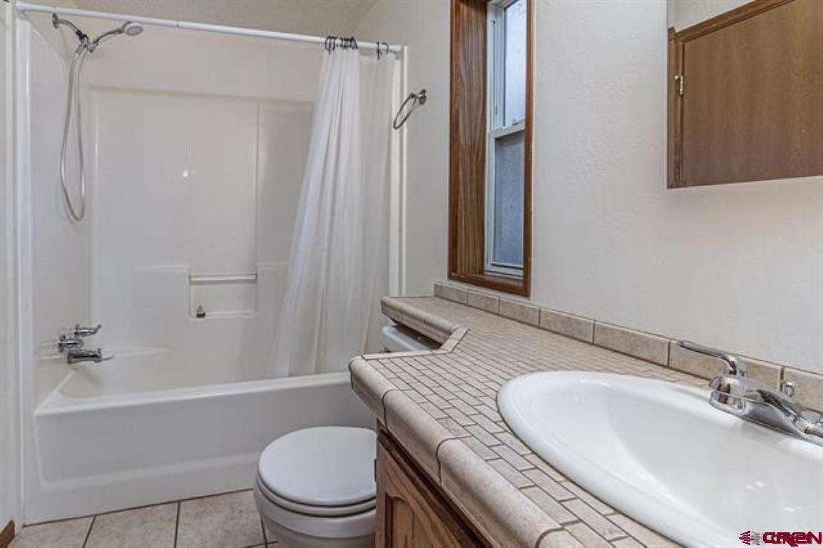 32 Hidden Lane Durango, CO 81303 - Photo 6 of 26 a bathroom with a granite countertop sink toilet a mirror and shower