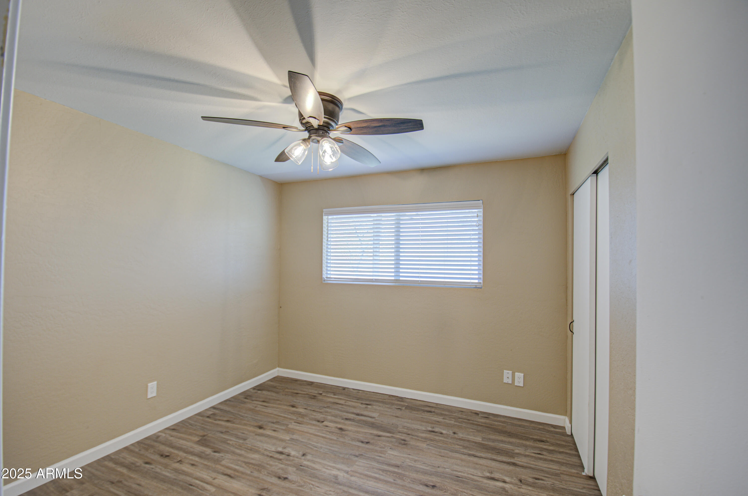 8050 South Bianco Road Casa Grande, AZ 85193 - Photo 71 of 96 an empty room with wooden floor chandelier fan and windows