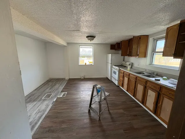 a kitchen with stainless steel appliances granite countertop a stove a sink and a refrigerator