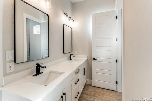 a bathroom with double vanity sink and a mirror