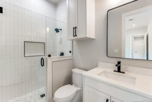 a bathroom with a sink a toilet and shower