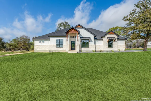 a front view of a house with a yard and trees