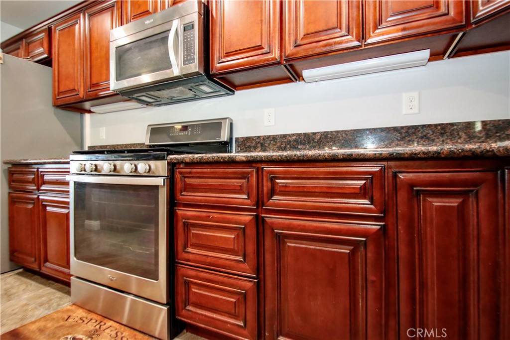 6202 Mandarin Road Yucca Valley, CA 92284 - Photo 12 of 24 a kitchen with stainless steel appliances granite countertop a stove and a microwave