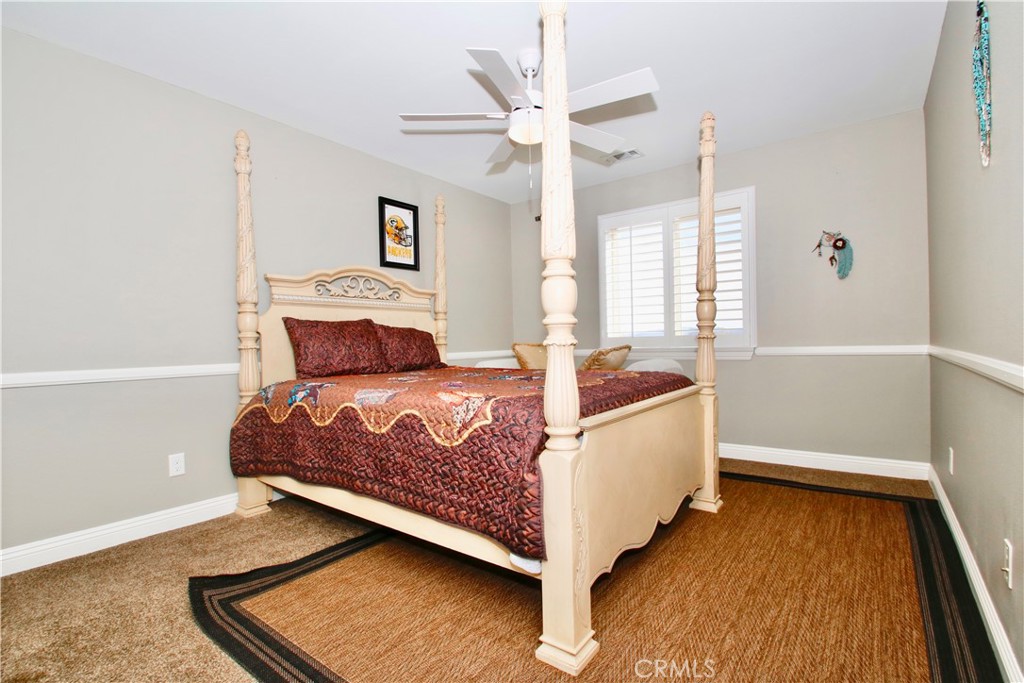 6202 Mandarin Road Yucca Valley, CA 92284 - Photo 17 of 24 a spacious bedroom with a bed and a chandelier