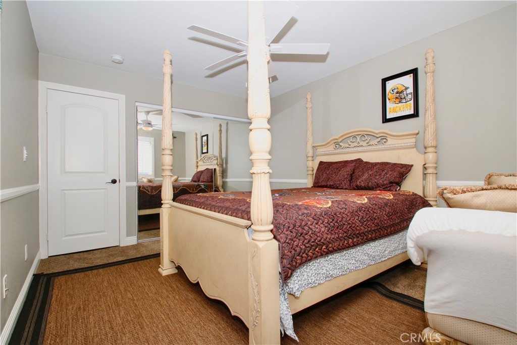 6202 Mandarin Road Yucca Valley, CA 92284 - Photo 20 of 24 a bedroom with a bed and a chandelier