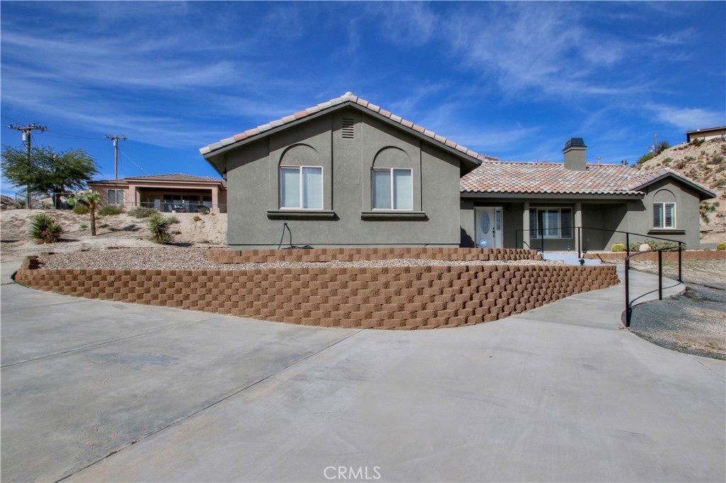 6202 Mandarin Road Yucca Valley, CA 92284 - Photo 2 of 24 a front view of a house with a yard