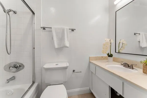a bathroom with a sink a toilet and shower
