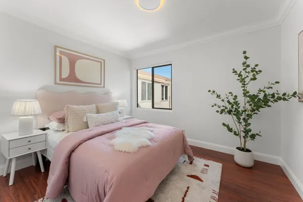 a bedroom with a large bed and a potted plant