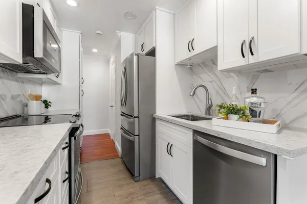 a kitchen with stainless steel appliances a sink stove and refrigerator