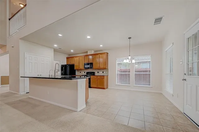 a kitchen with stainless steel appliances granite countertop a refrigerator and a stove top oven