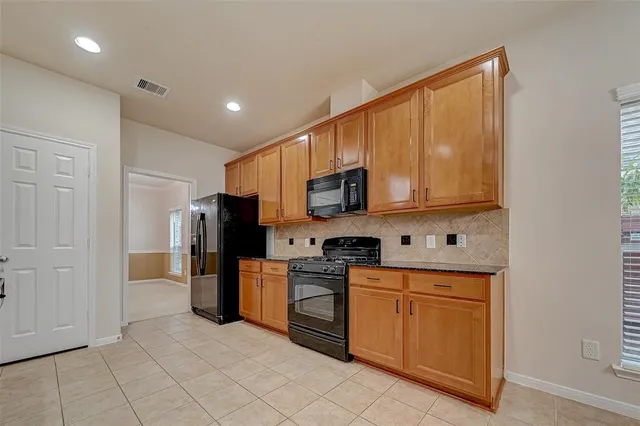 a kitchen with stainless steel appliances granite countertop a refrigerator a stove top oven a sink and dishwasher
