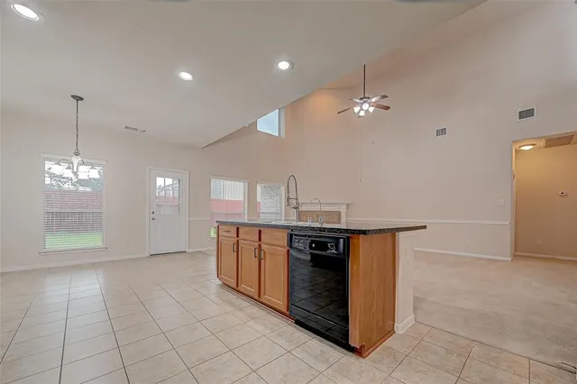 a view of kitchen with granite countertop stove top oven and cabinets