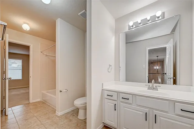 a bathroom with a toilet a sink a vanity and mirror
