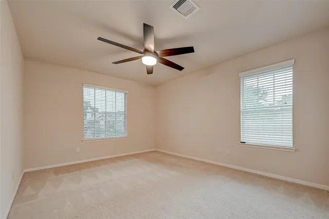an empty room with a window and a fan