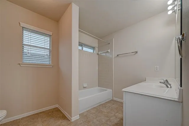 a bathroom with a tub sink and mirror