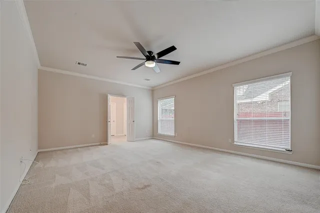 an empty room with windows and ceiling fan