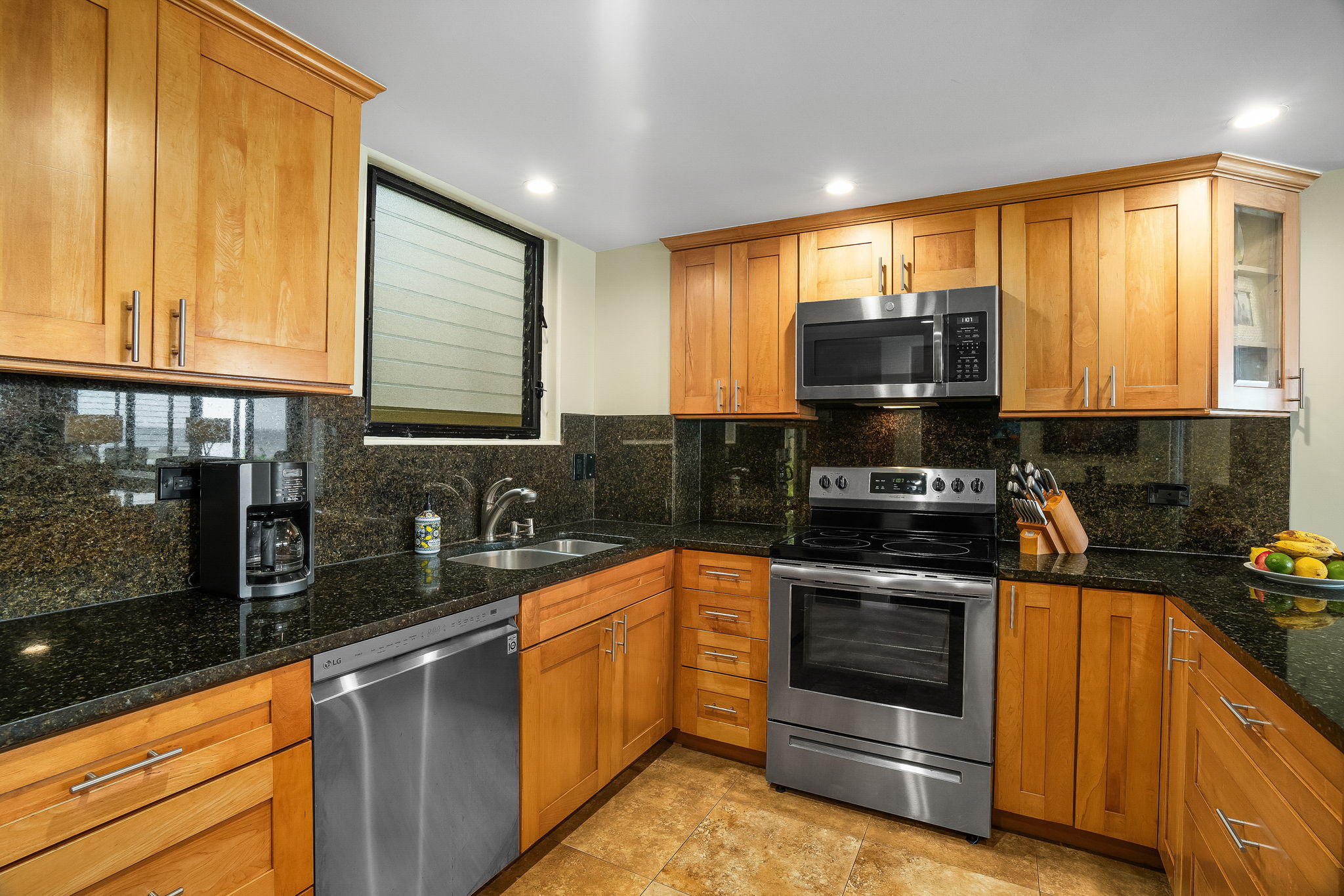 1775 Pe'e Road, Unit 101A Koloa, HI 96756 - Photo 7 of 25 a kitchen with stainless steel appliances a stove a sink and a microwave