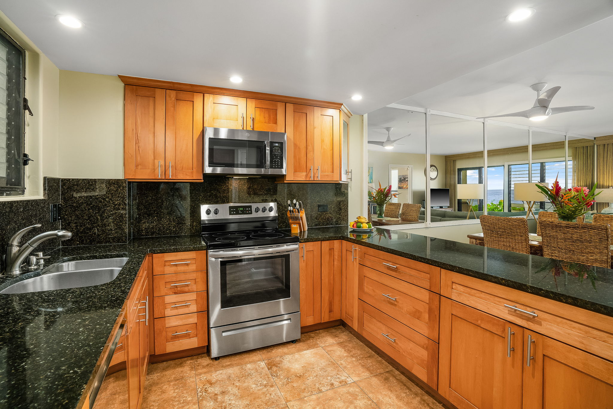 1775 Pe'e Road, Unit 101A Koloa, HI 96756 - Photo 8 of 25 a kitchen with stainless steel appliances granite countertop a stove a sink and a microwave