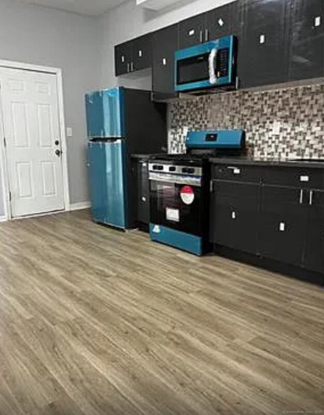 a kitchen with stainless steel appliances granite countertop a refrigerator and a wooden cabinets