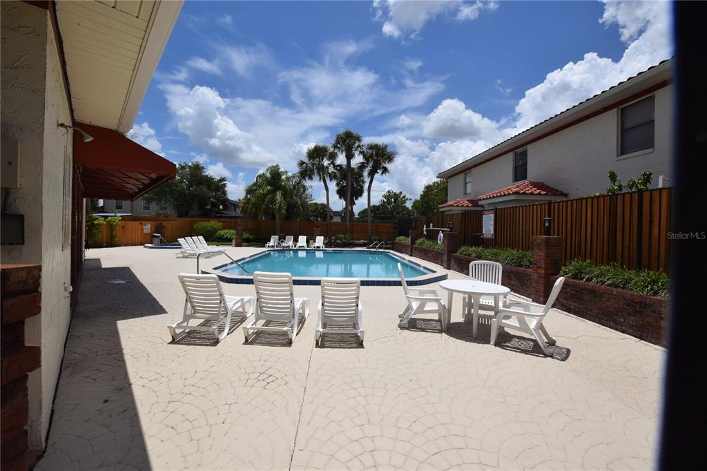 1621 Sandy Point Square, Unit 61 Orlando, FL 32807 - Photo 2 of 3 a view of a patio with table and chairs potted plants with wooden floor