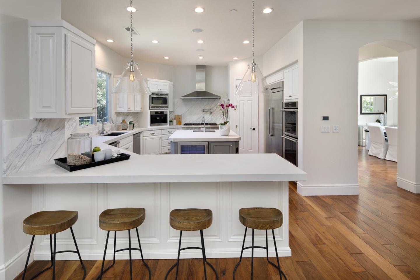 782 Dixon Way Los Altos, CA 94022 - Photo 5 of 38 a kitchen with stainless steel appliances kitchen island granite countertop a dining table chairs and white cabinets