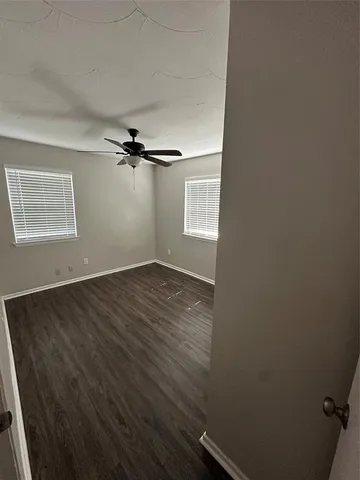 an empty room with a window and a ceiling fan