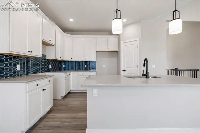 a kitchen with stainless steel appliances granite countertop a sink a window a refrigerator and wooden floor