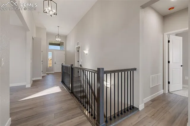 a view of an empty room with wooden floor fireplace and a window