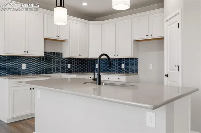a kitchen with white cabinets and sink